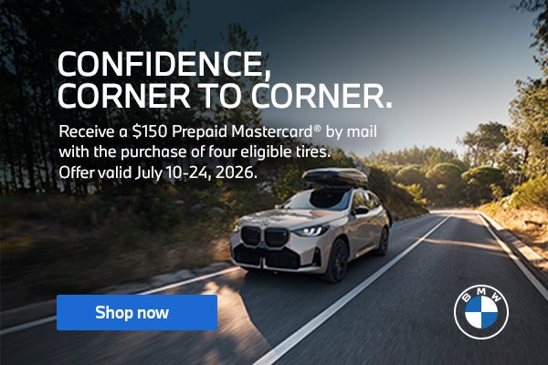 A front, three quarter view of white BMW X3 is driving on a 